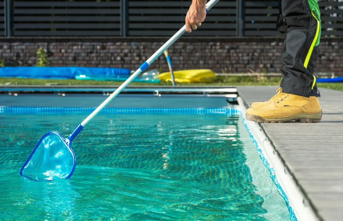 Weekly Pool Maintenance Rockledge FL — technician skimming a backyard pool — Knight Institutes, LLC