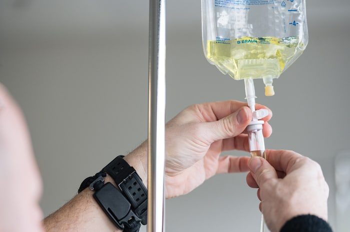 Nurse administering IV therapy to patient's hand