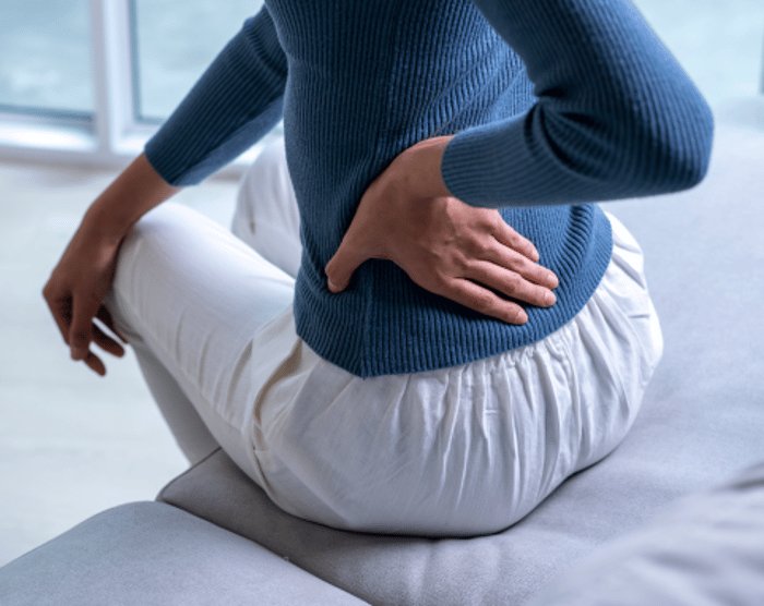 A chiropractor or physical therapist performing a hands-on adjustment or massage on a patient's lower back