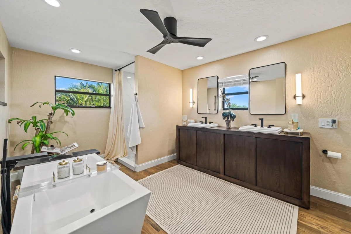 Luxury primary suite bathroom with soaking tub, double sinks, and walk-in closet
