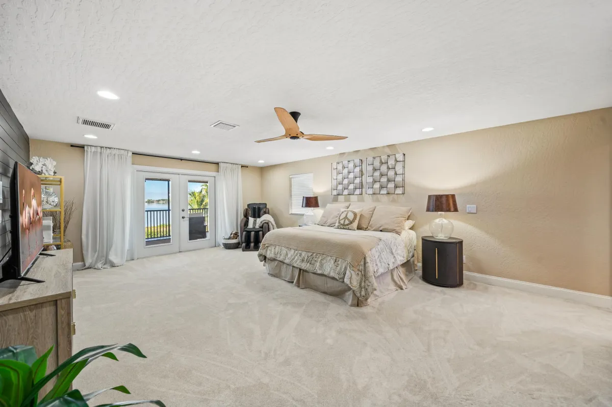Primary bedroom with screened balcony and river view in Tortoise Island home