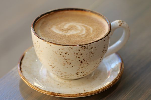Cup of latte with foam art on table at Serai Cafe & Deli, Lincoln Park