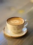 Cup of latte with foam art on table at Serai Cafe & Deli, Lincoln Park