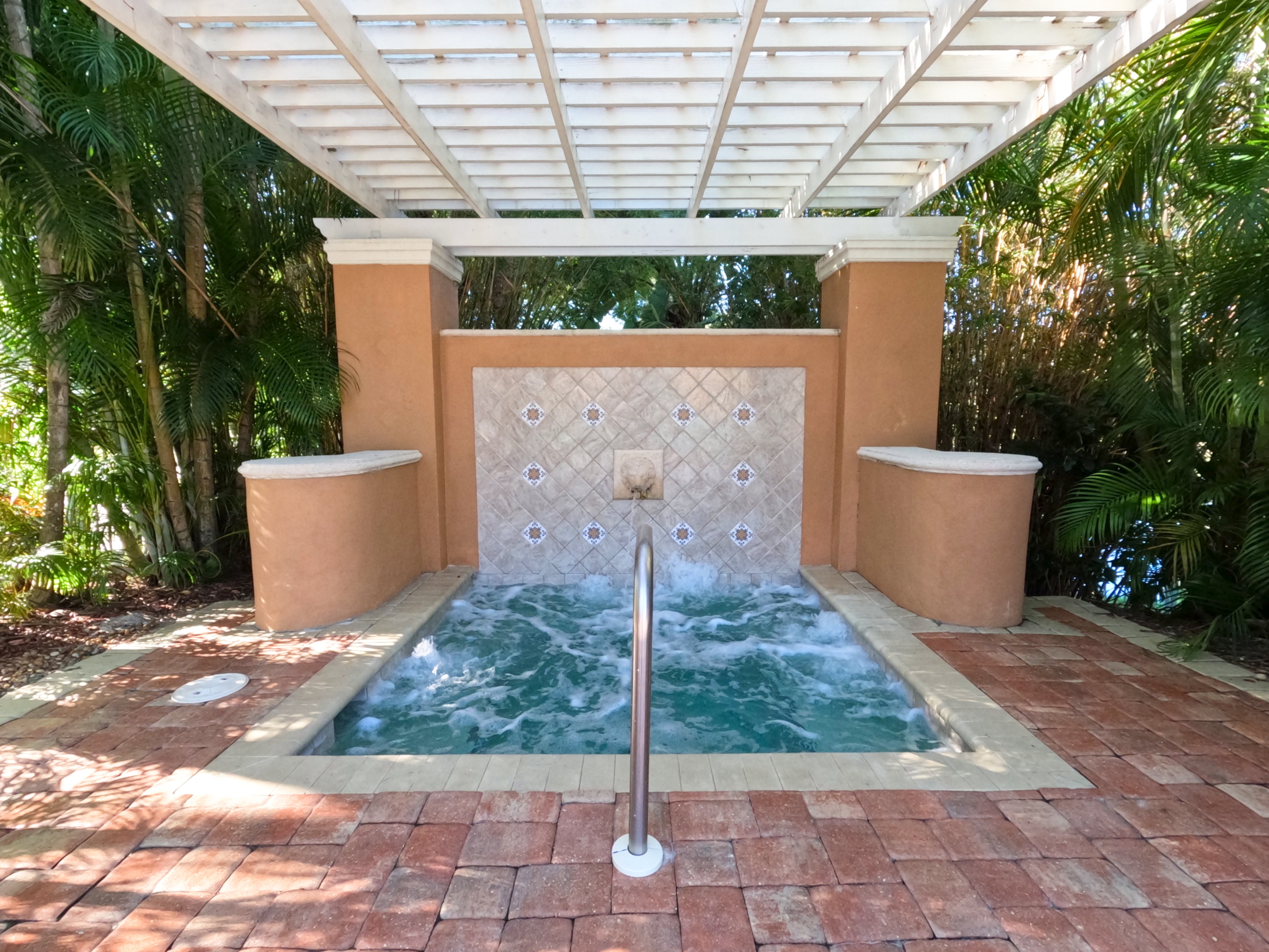 "Bubbling hot tub under the stars in resort community, perfect evening relaxation for guests at Royal Palm Retreat Naples monthly stay"