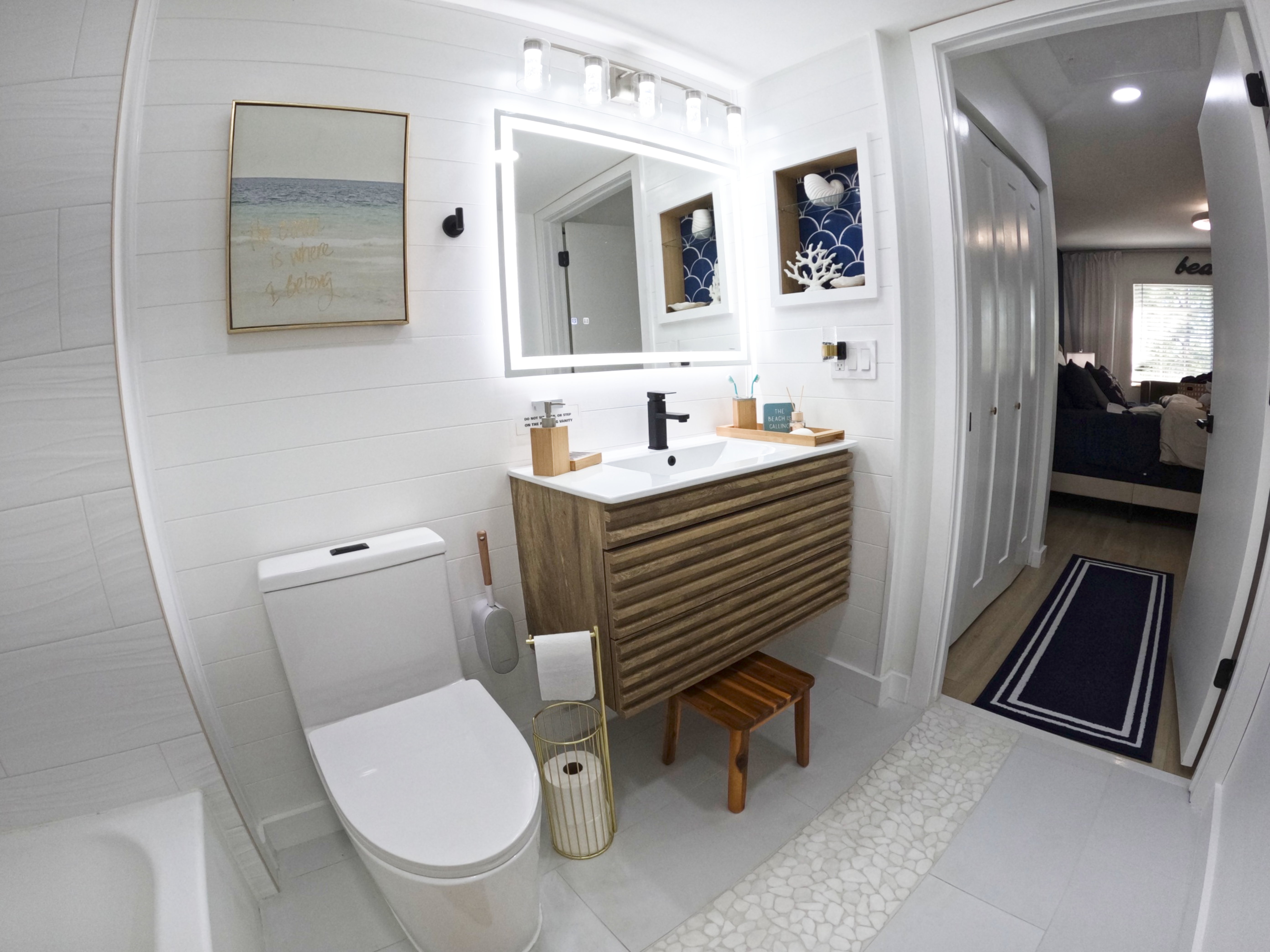 "Luxurious master bathroom with bright white finishes and beachy sconces in Royal Palm Retreat, monthly condo rental Naples Florida"