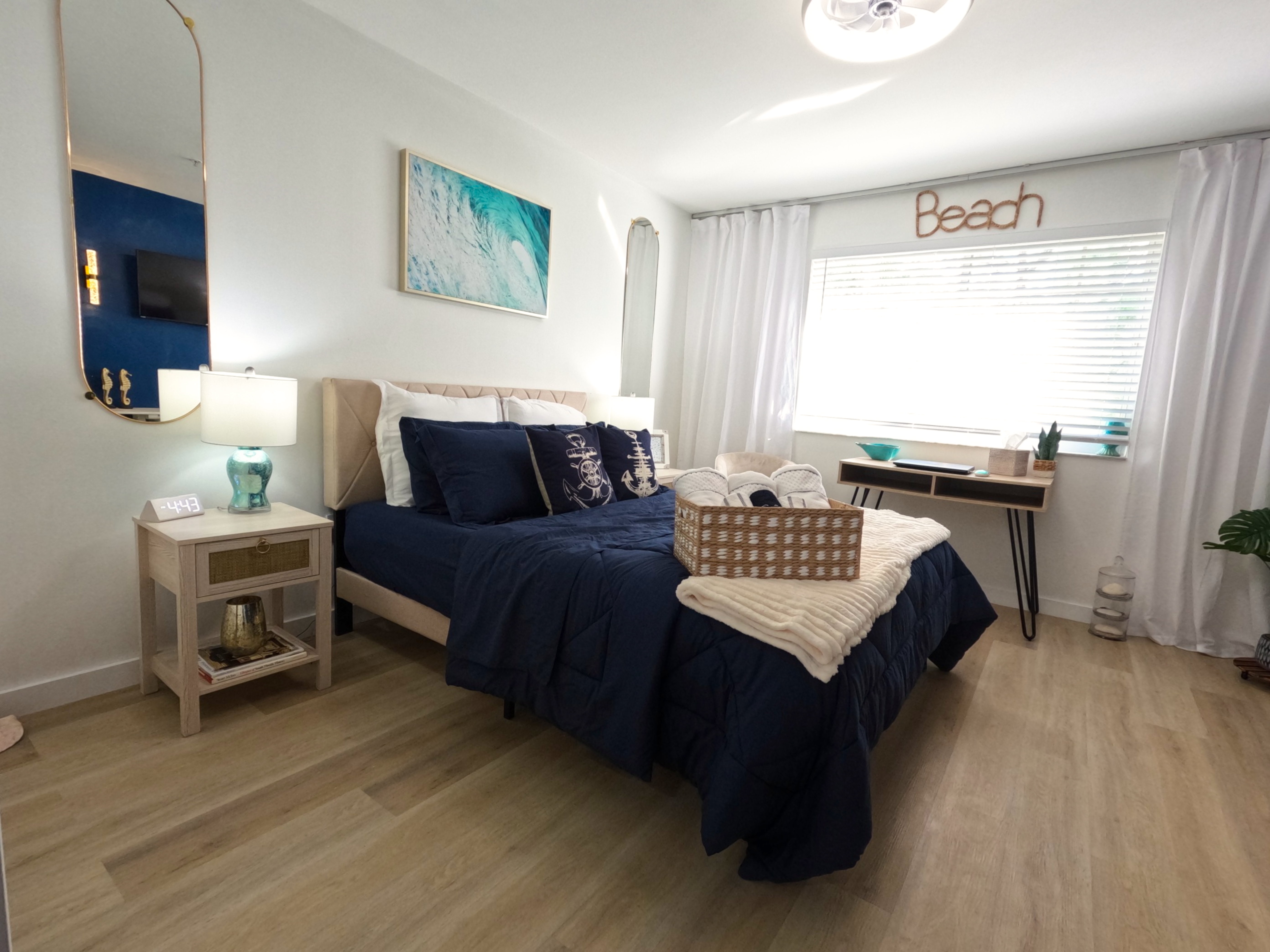 Guest Bedroom Setup: "Cozy guest bedroom sleeps 2 in bright white and navy decor at Royal Palm Retreat, family-friendly monthly rental near Vanderbilt Beach."