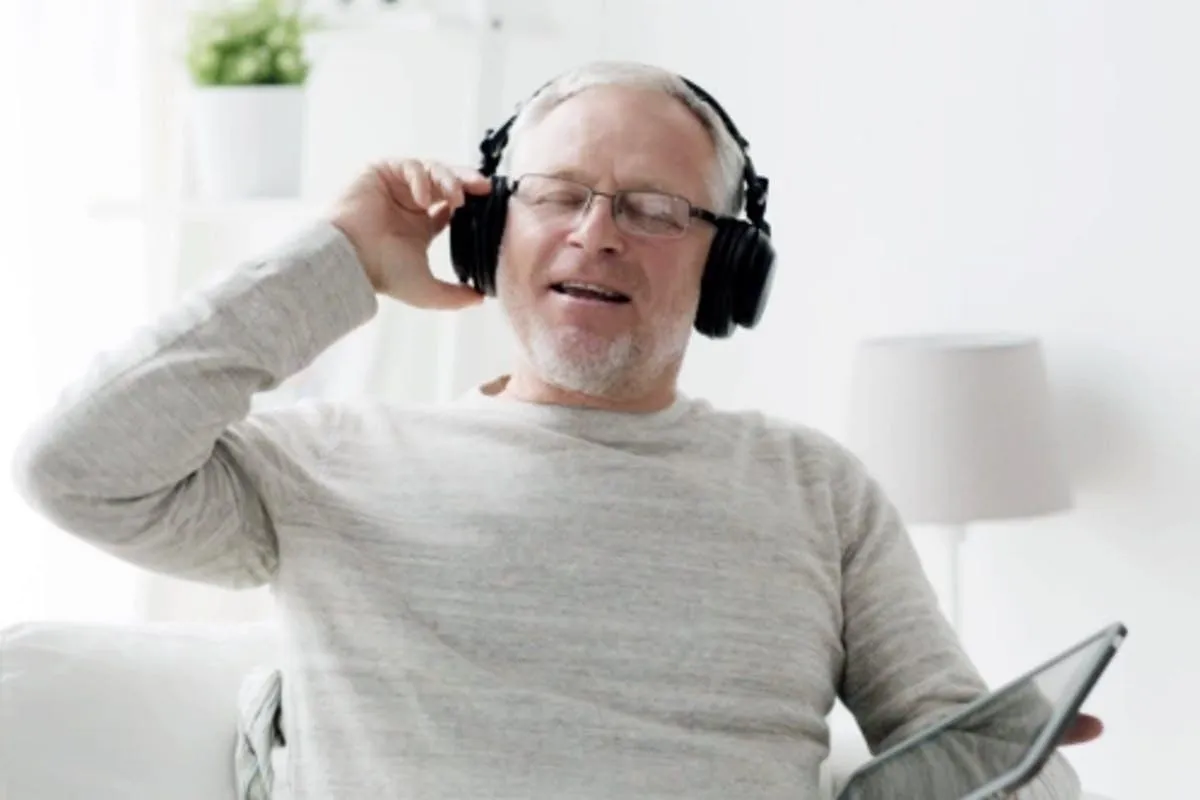 Man relaxing and listening to hypnotherapy recordings with headphones