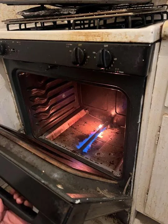 Gas oven burner with flame during professional oven repair by Sammy Appliance Repair in NYC