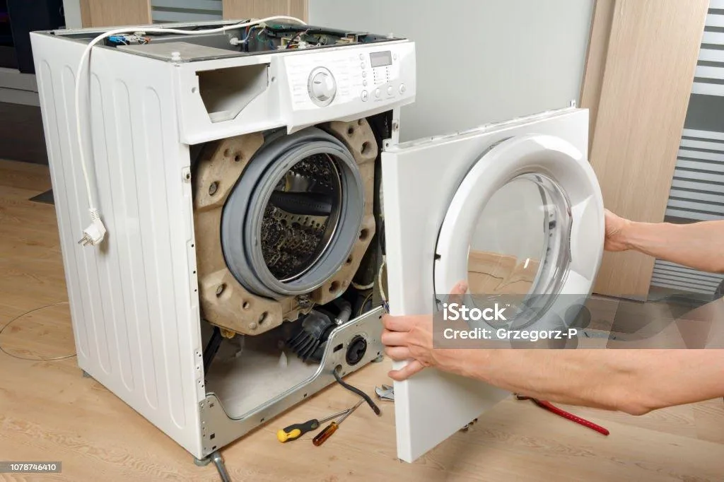 Open washing machine with technician inspecting drum for repairs by Sammy Appliance Repair in Queens