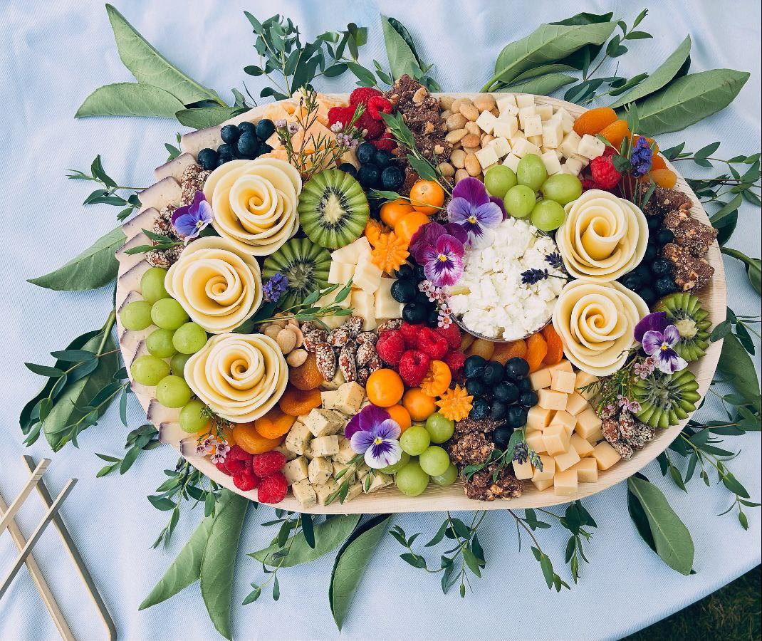 a wooden plate topped with different types of cheese