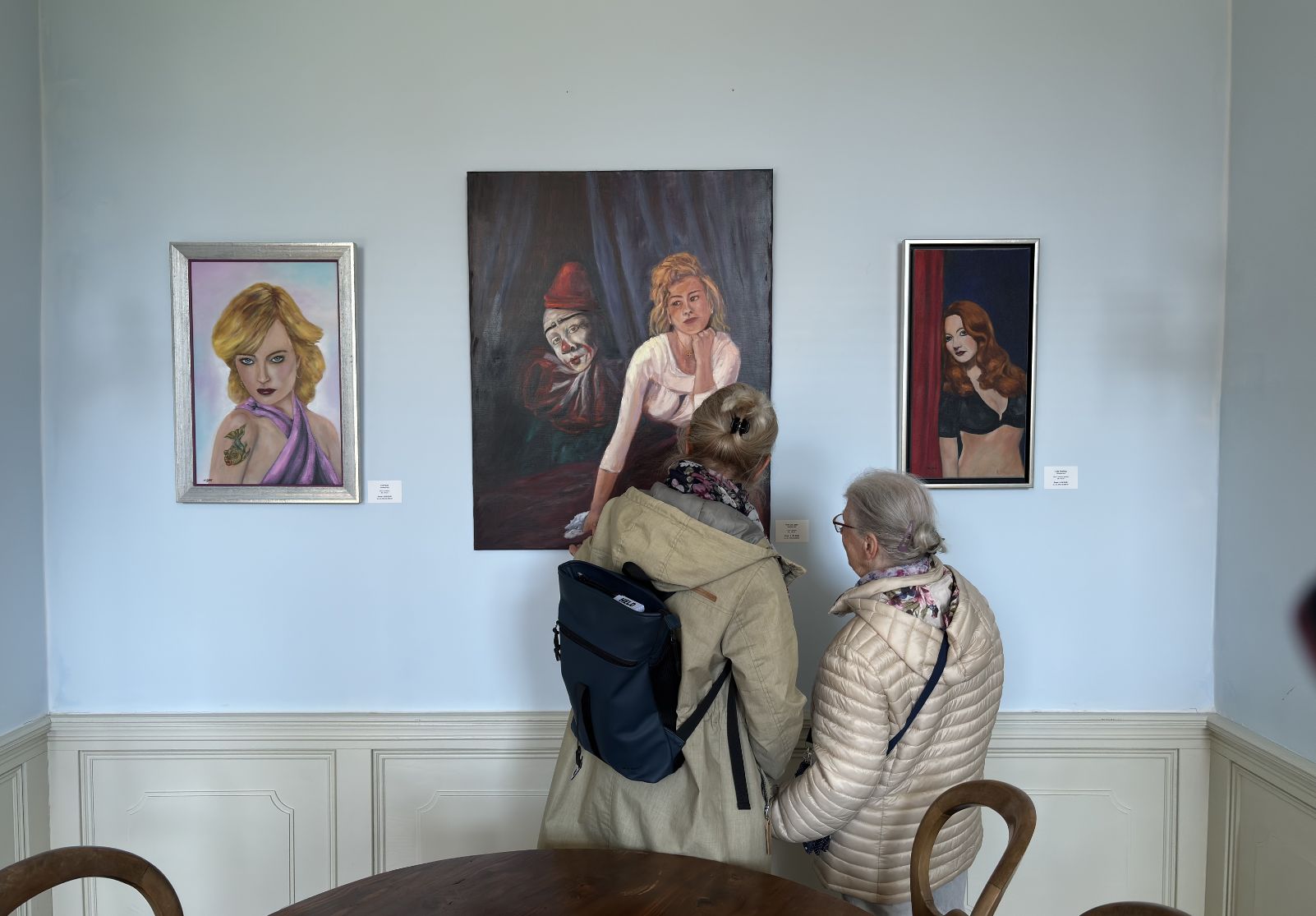 Besucher betrachten figurative Gemälde von Christine Graf in der Favori Art Ausstellung „Favori No.1 – GENESIS“ im Schloss Gleina.