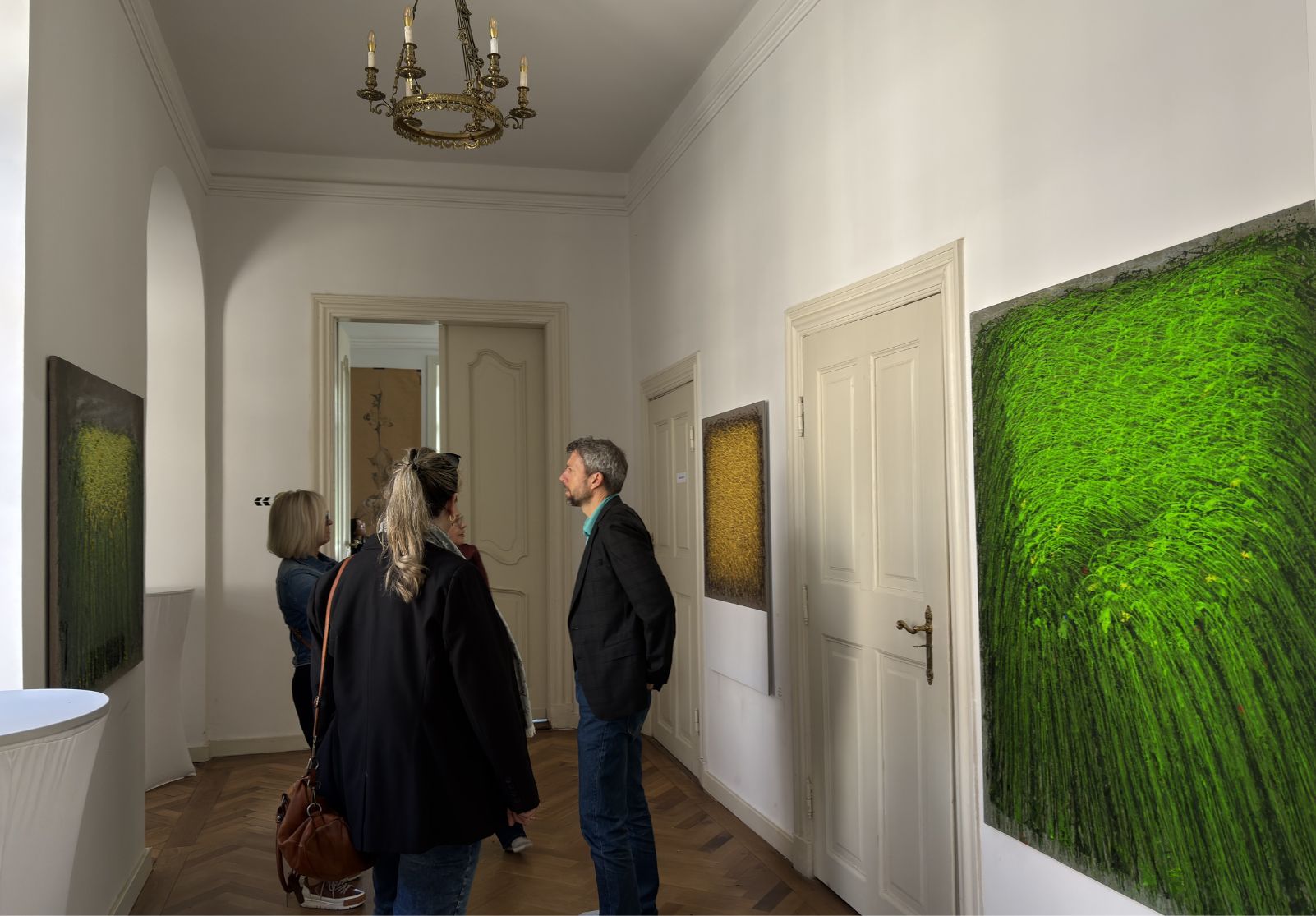 Besucher betrachten abstrakte Gemälde in der Favori Art Ausstellung „Favori No.1 – GENESIS“ im historischen Schloss Gleina.