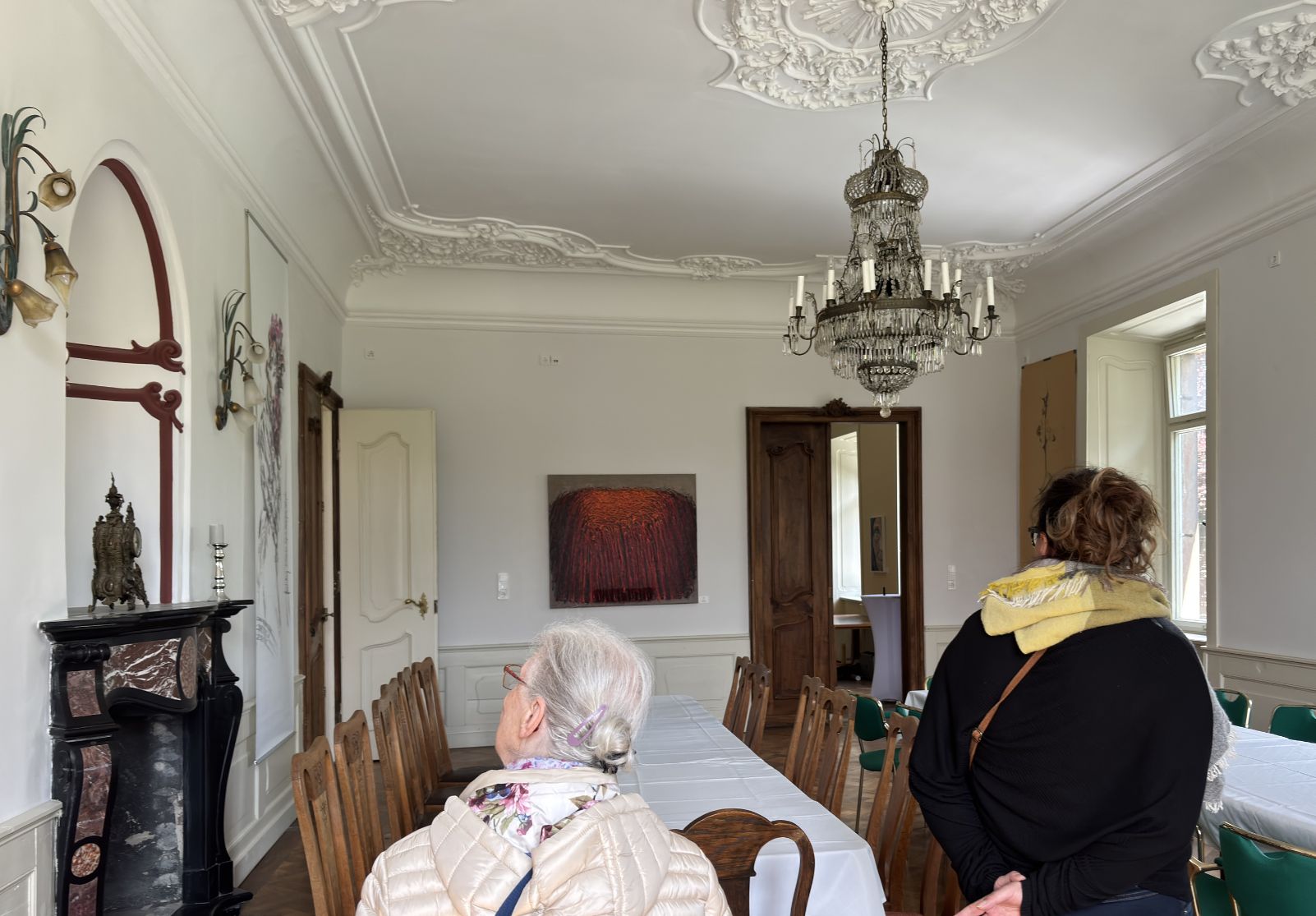 Besucherinnen betrachten zeitgenössische Kunstwerke in der Favori Art Ausstellung „Favori No.1 – GENESIS“ im historischen Schloss Gleina.