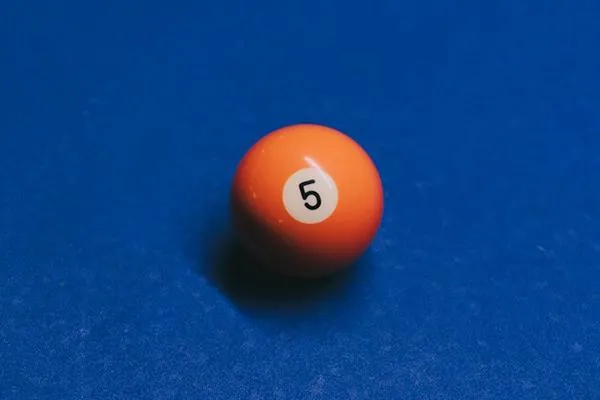 Image shows orange pool ball with the number five on it 