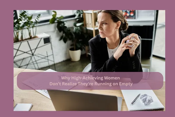 High-achieving woman sitting at her desk looking focused but visibly fatigued, representing hidden burnout and mental exhaustion