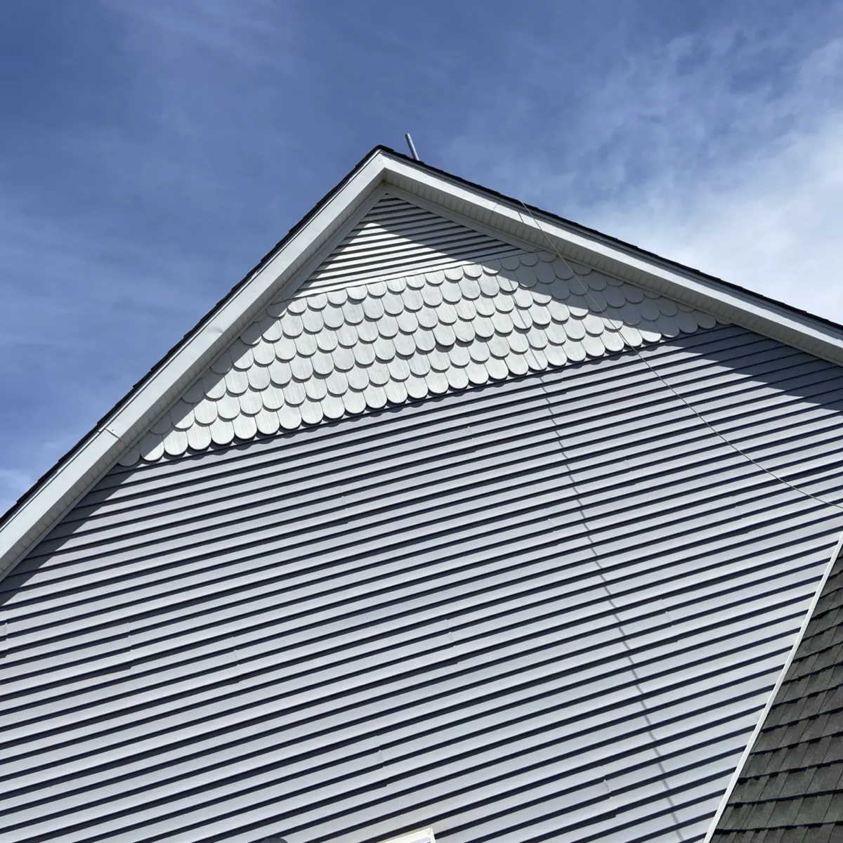 Gray Metal Roof Gable Near Siding Installation in Oklahoma