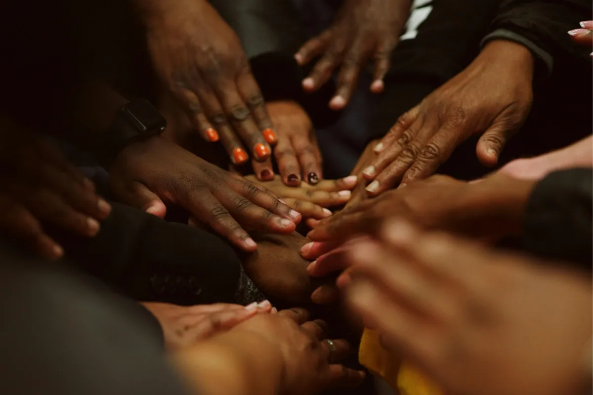 five human hands on brown surface
