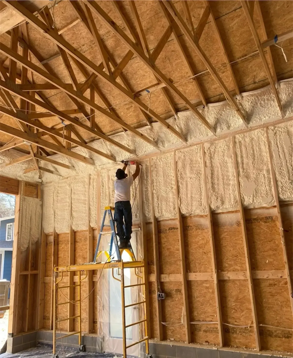 Smithfield team spraying foam to seal attic rafters efficiently