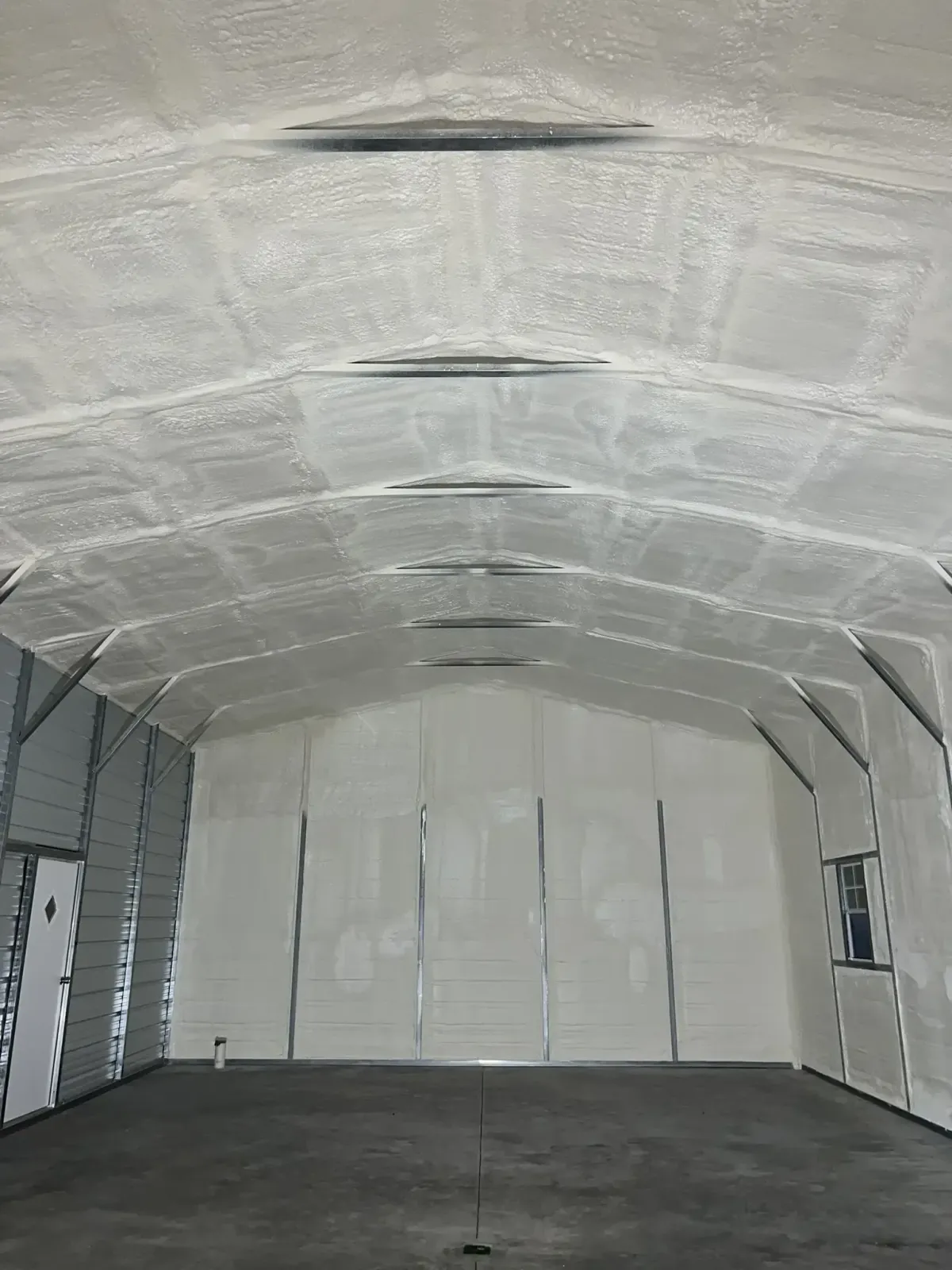Technician installing insulation under roof decking in Chapel Hill