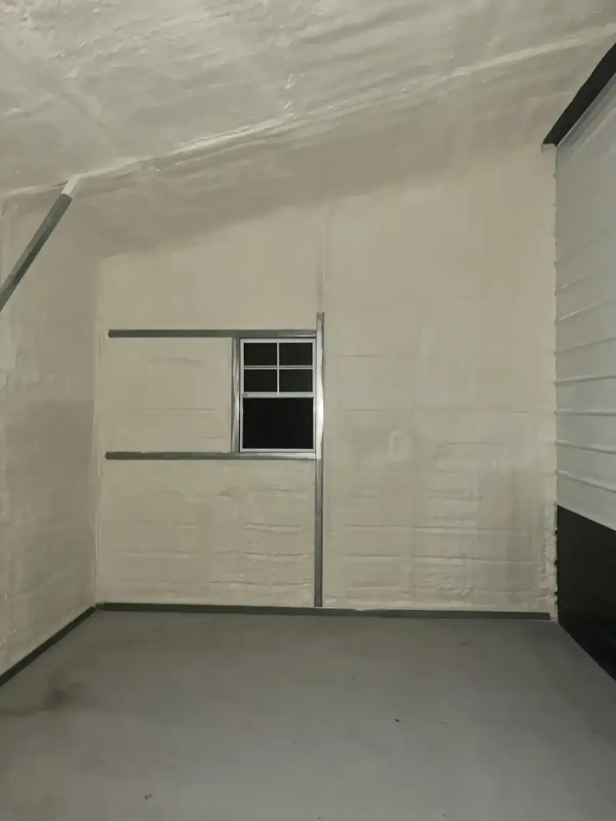 Closed-cell spray foam insulation creating airtight seal in garage interior for energy efficiency in Raleigh, NC