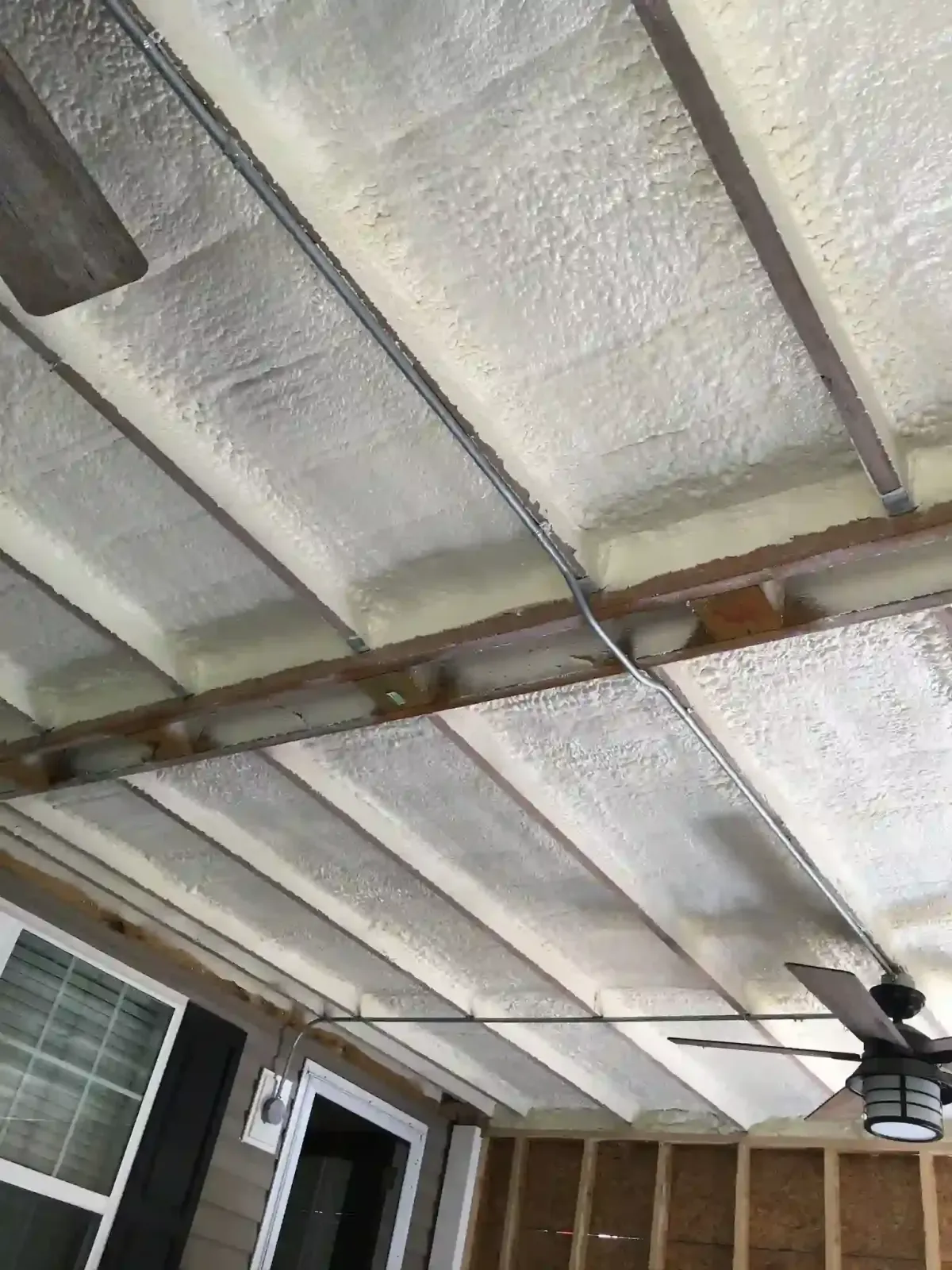Closed-cell spray foam insulation applied to outdoor ceiling of residential home in Clayton, NC for moisture control and durability