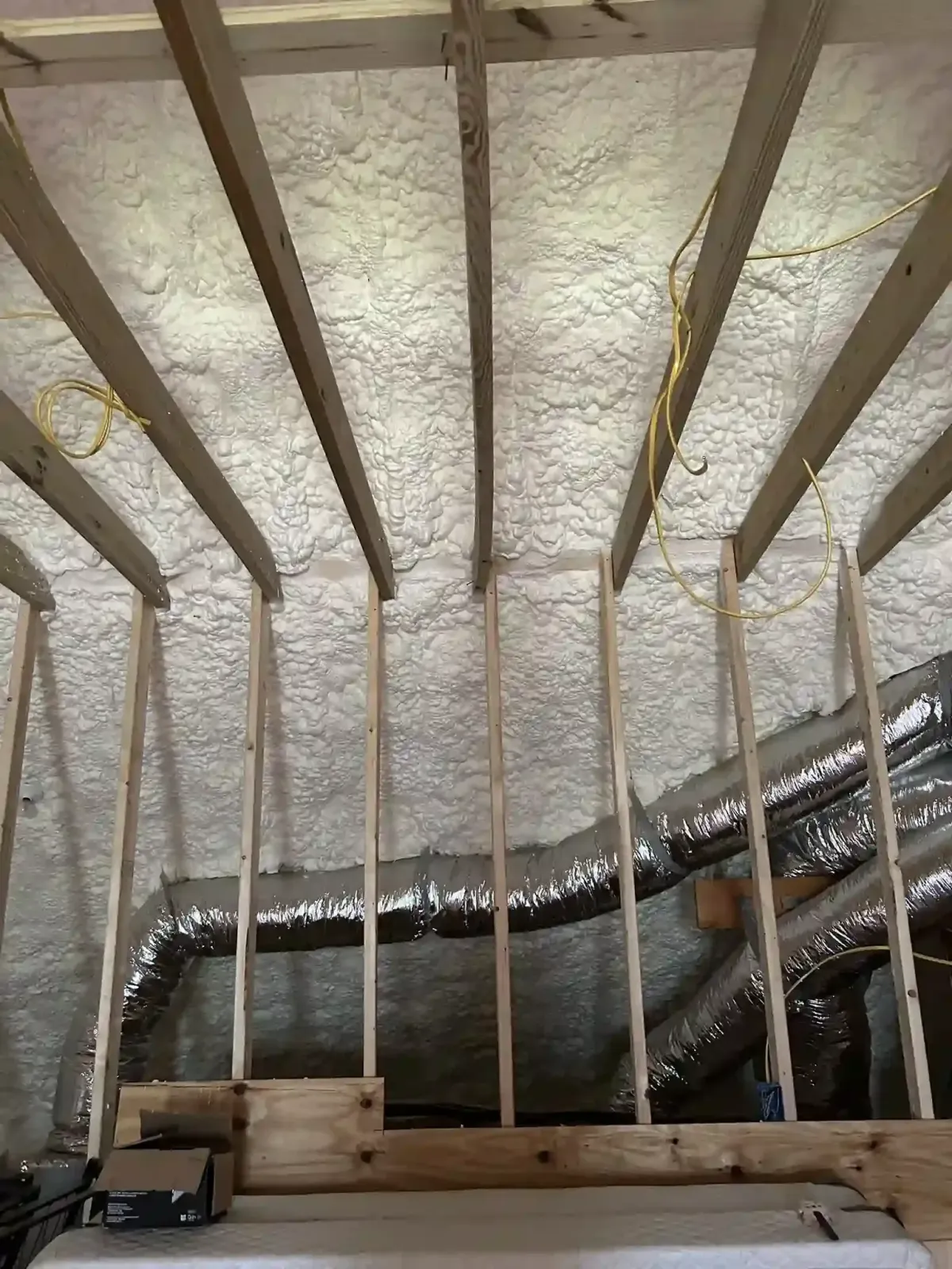 Open-cell spray foam insulation installed in attic ceiling above ductwork in Smithfield, NC for energy efficiency and air sealing
