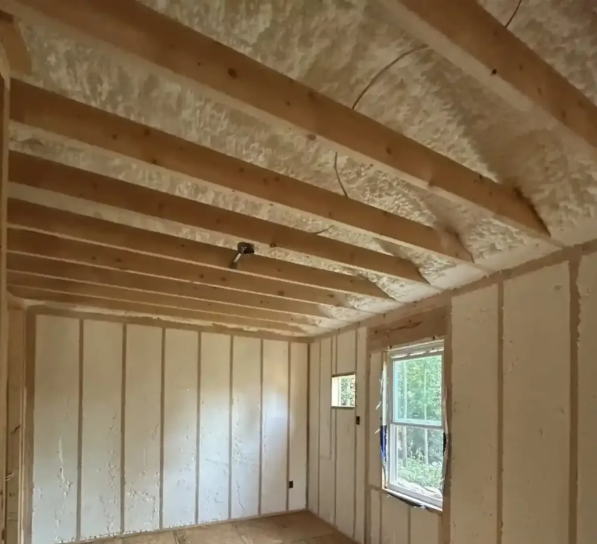 Open cell spray foam insulation in residential room for energy efficiency, soundproofing, and air sealing