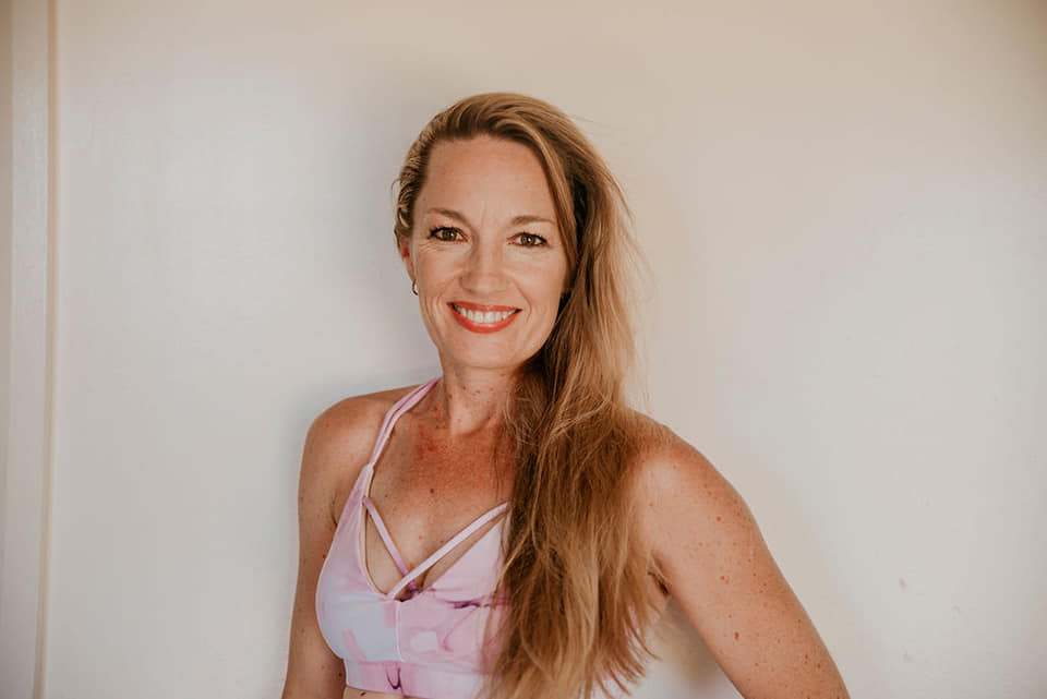 A diverse group of adults in modern activewear, mid-motion in a bright, minimalist gym, smiling and supporting each other during a group fitness session. The background is softly blurred, emphasising energy and camaraderie. Clean, contemporary style, 3:2 aspect ratio.