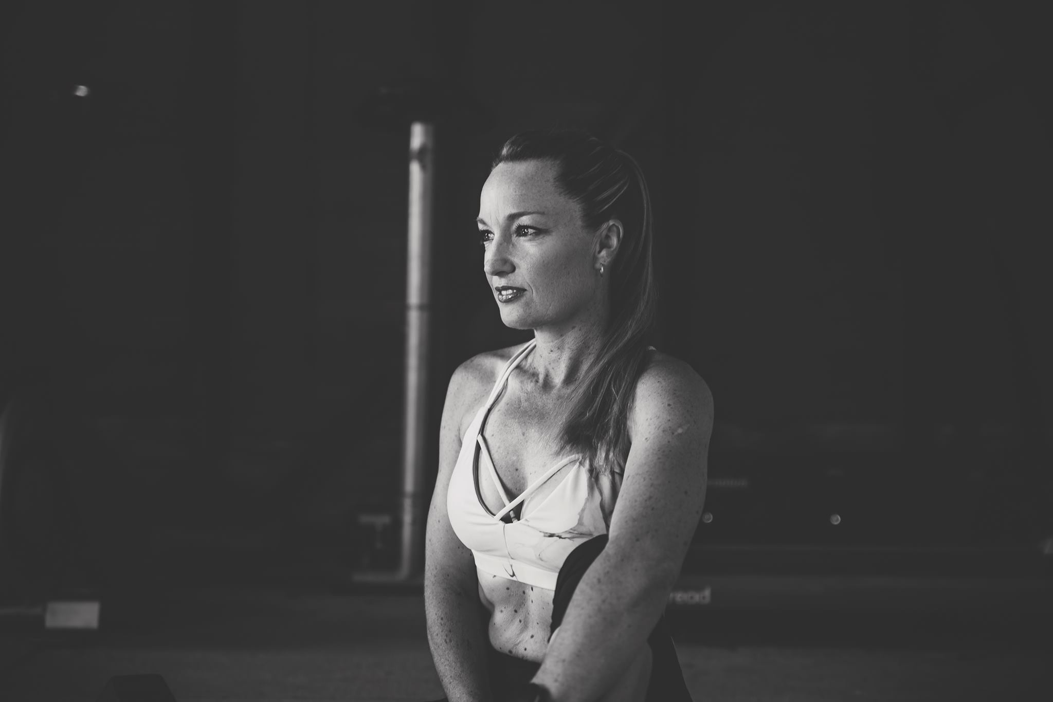 A diverse group of adults in modern activewear, mid-motion in a bright, minimalist gym, smiling and supporting each other during a group fitness session. The background is softly blurred, emphasising energy and camaraderie. Clean, contemporary style, 3:2 aspect ratio.