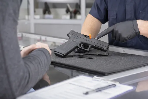 Customer inspecting a safely displayed firearm before completing a transfer at ISFA-4 Defense Supply Company.