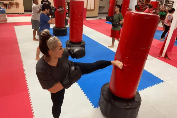 person kicking heavy bag with intensity