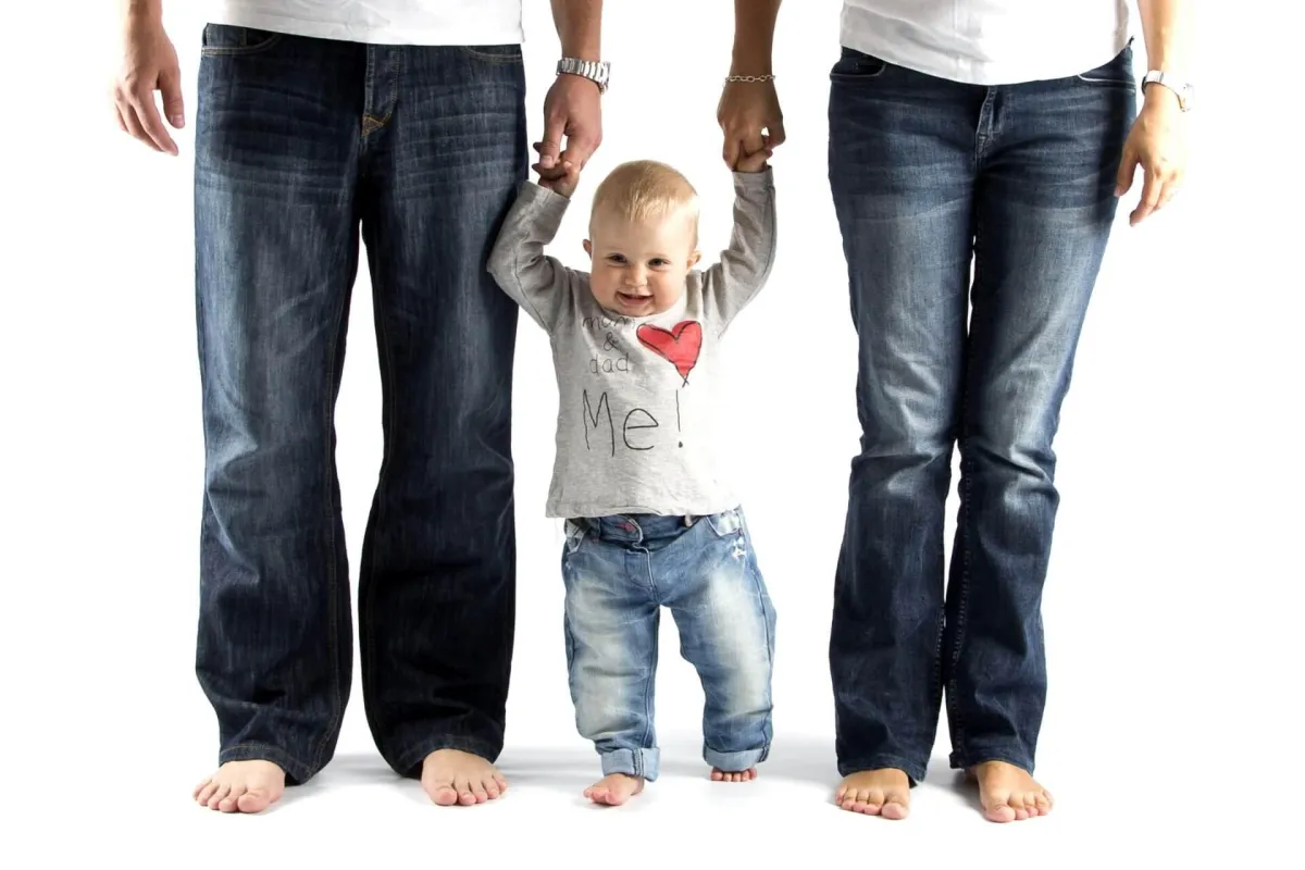 Family holding handings with child, happily insured with term life insurance and whole life insurance for parents & child