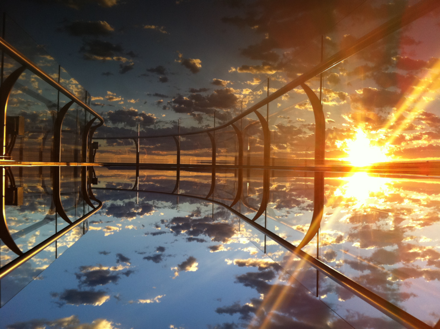 Sunset view from the Grand Canyon Skywalk with golden light reflecting on the glass walkway