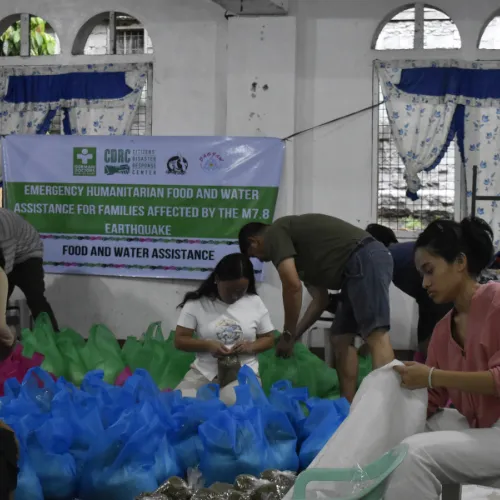 Volunteers packing emergency relief food boxes and supplies