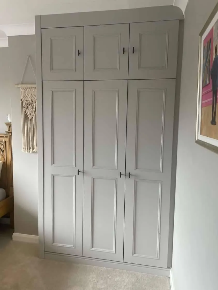 Floor-to-ceiling fitted wardrobe in light grey with six Shaker-style panels and matte black handles