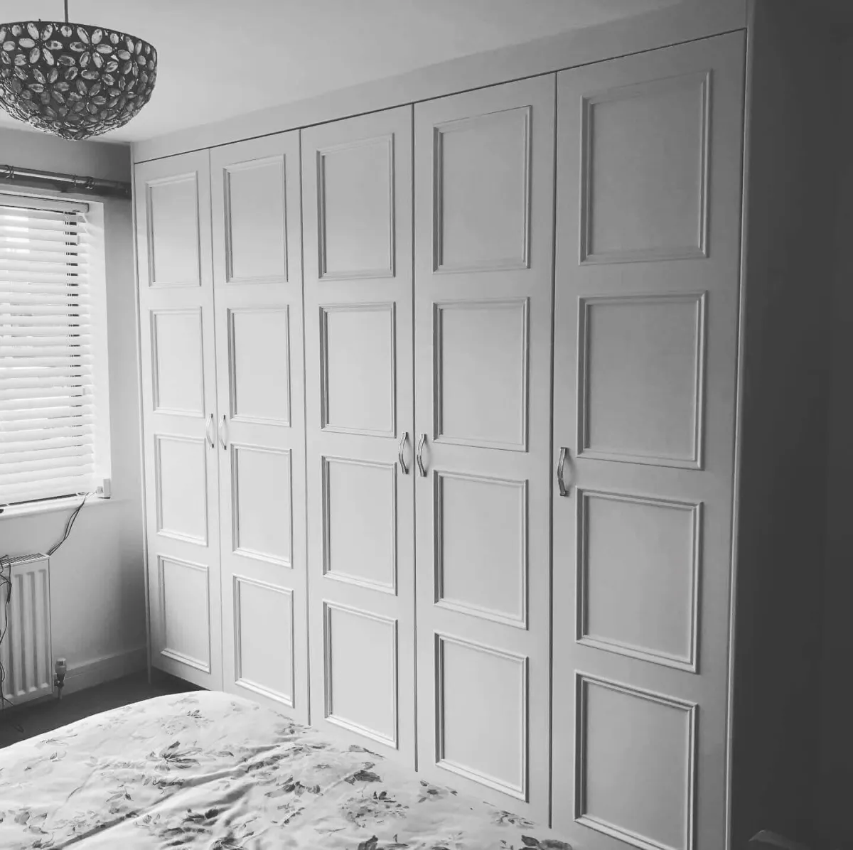 Floor to ceiling fitted wardrobe with five paneled doors in white, featuring classic Shaker style detailing