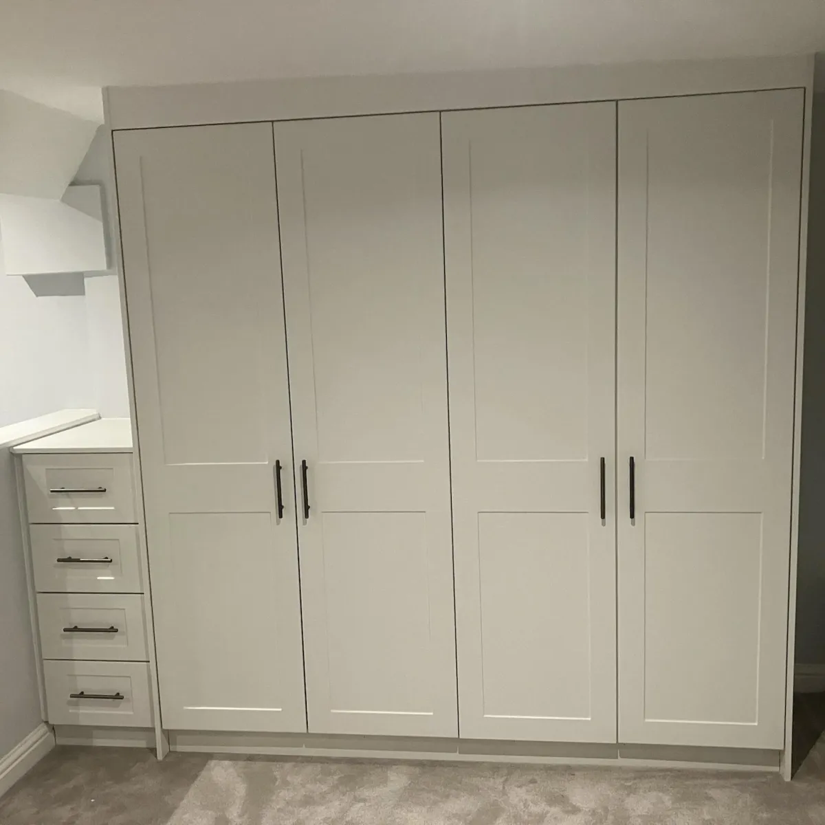 Bespoke fitted wardrobes Yorkshire with shaker-style doors and drawer unit in luxury white finish