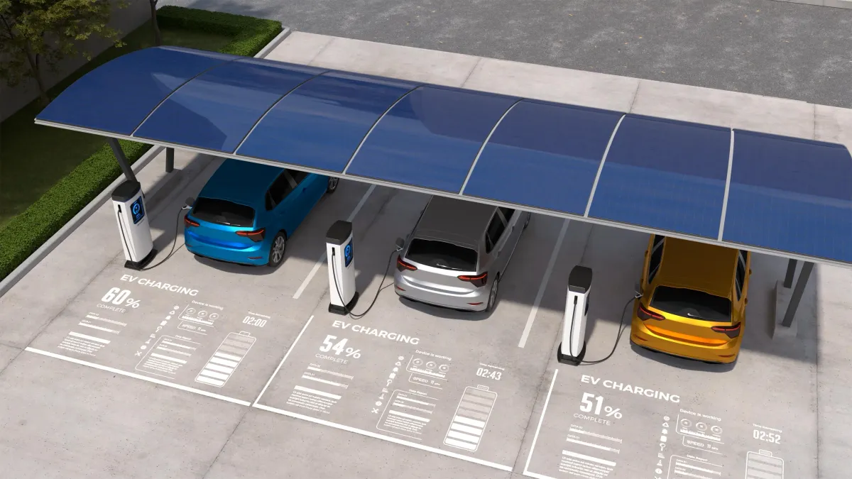Modern solar carport with integrated EV charging stations, sheltering electric vehicles in a parking lot and displaying digital charge data for each vehicle.