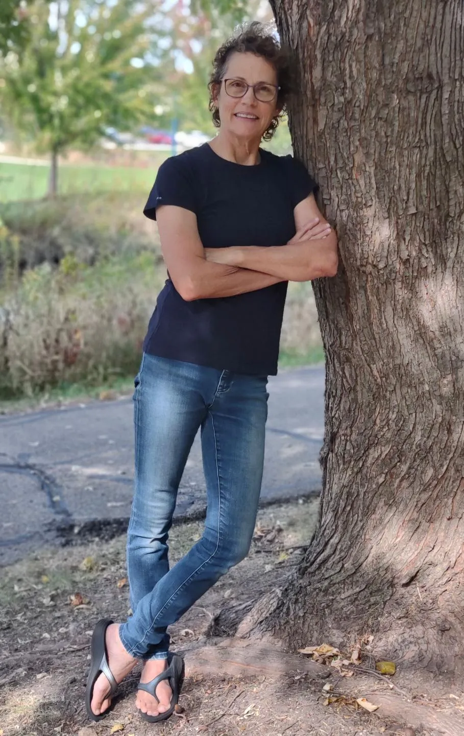 Mary leaning against a tree with hand on her heart