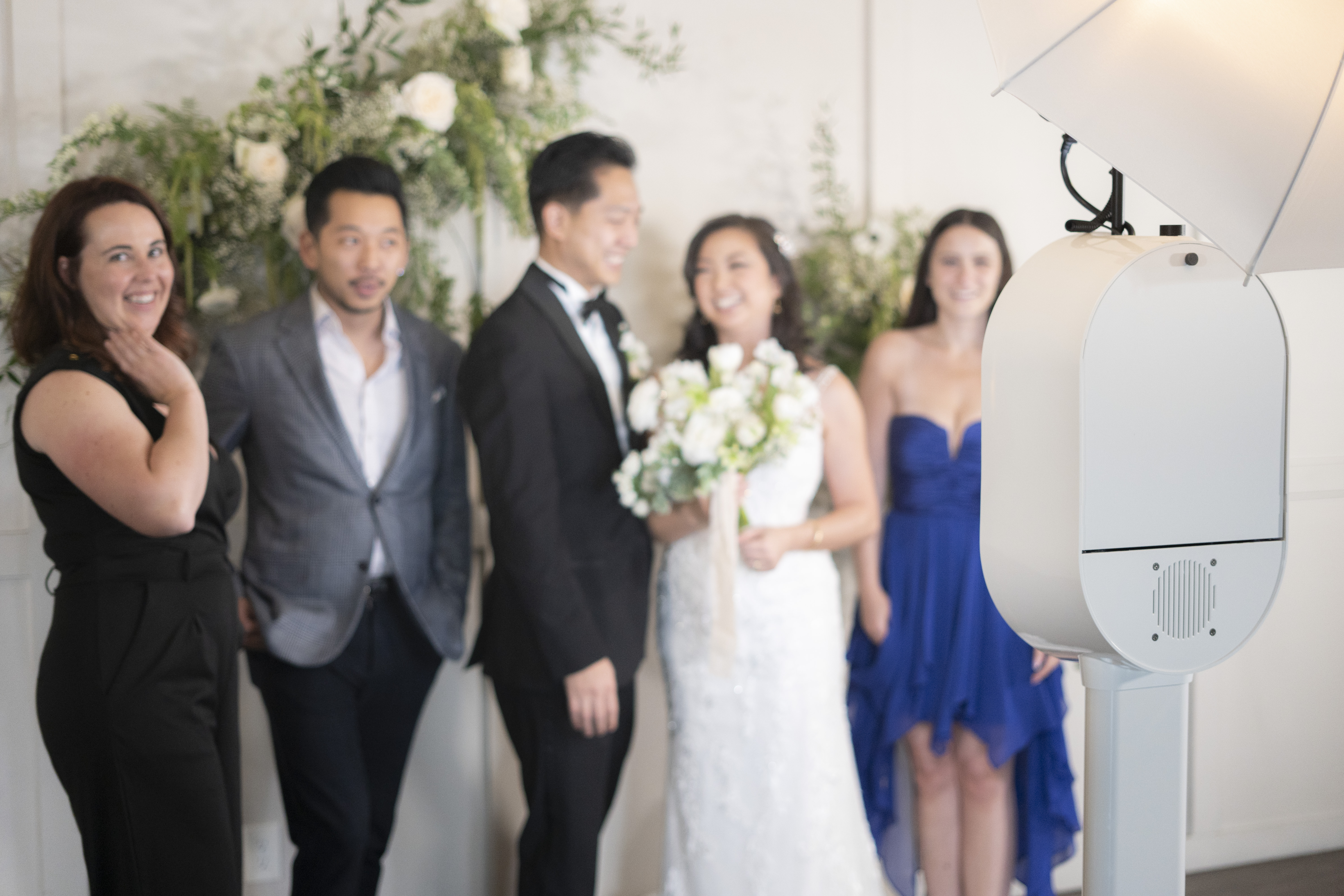 Bride and groom enjoying candid photos with wedding photo booth props