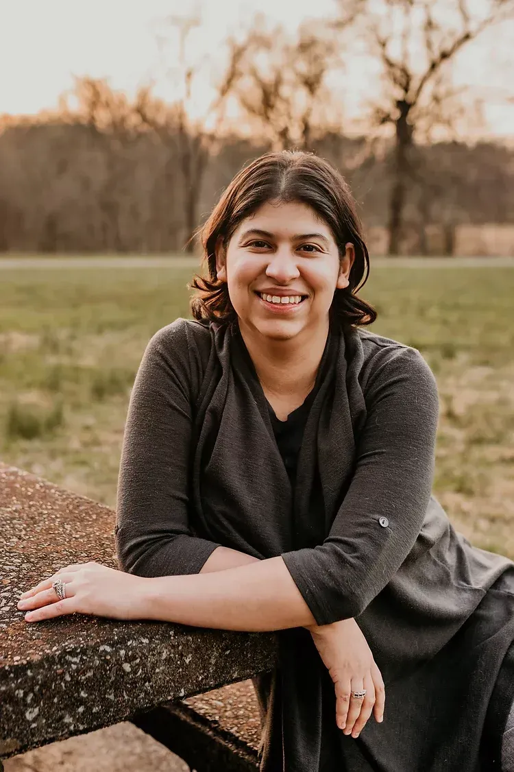 Image of Rebecca Bautista leaning against a picnic table at a local park