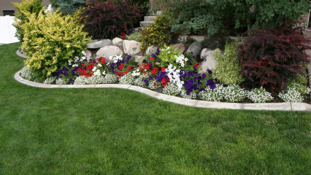 Colorful landscaped flower bed with stone edging - Perfect Trim Lawn & Landscaping - landscaping design services in Antioch