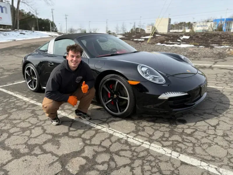 Matt, the owner of Polish Plus Detailing, posing in front of a recently detailed Porsche