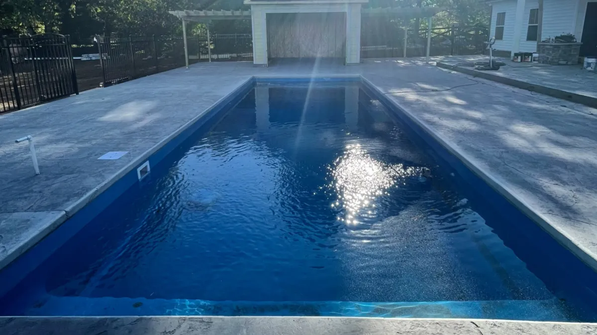 A man standing next to a swimming pool
