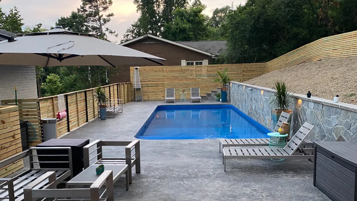 A large swimming pool with a lounge chair next to it