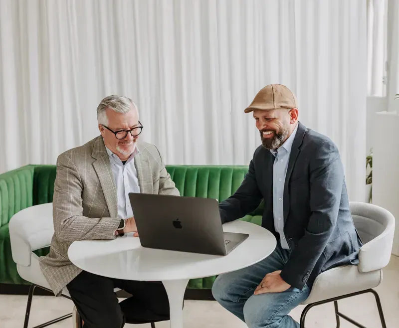 Marketing agency executives reviewing client performance on laptop