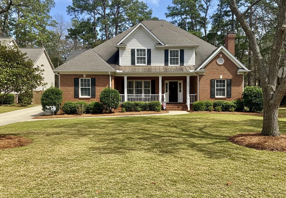 Well-manicured front yard in Atlanta featuring trimmed hedges, small decorative trees, and a freshly mowed lawn