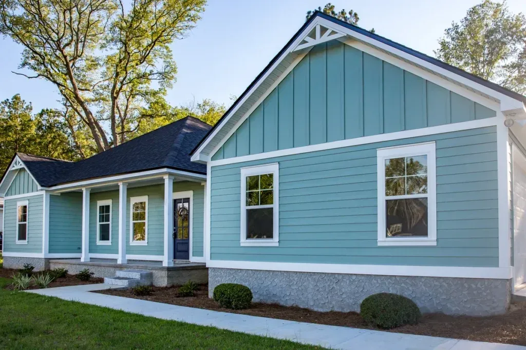 Exterior of a modern blue house with white trim and front porch, showcasing professional painting services by Copeland Painting in Paducah, KY.