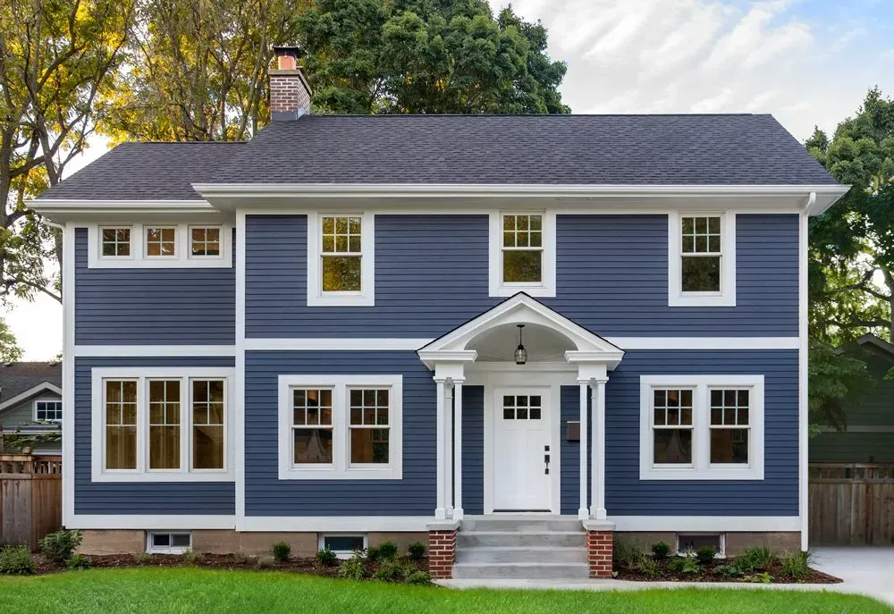Blue vinyl siding house with white trim and a welcoming front porch, showcasing professional exterior painting by Copeland Paintings in Paducah, KY.