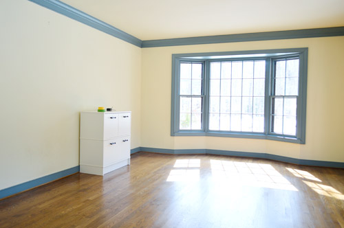 Interior room with light-colored walls, blue trim, hardwood floor, and a white storage unit, showcasing a bright, spacious environment ideal for interior painting services in Paducah, KY.
